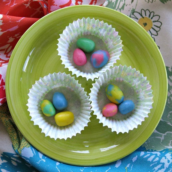 3 cupcake holders with 3 pieces of buttermint candy in each one on a plate