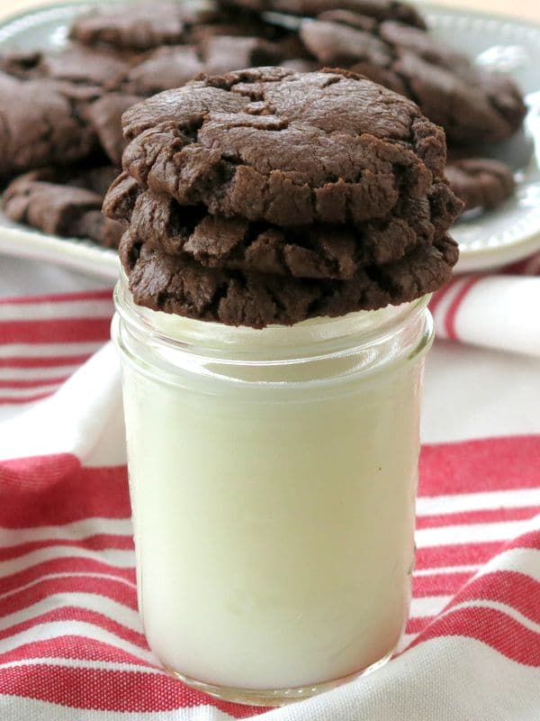 3 Molten Lava Chocolate Chip Cookies stacked on top of a glass of milk