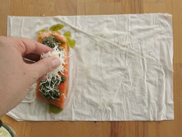 Salmon on top of phyllo dough sheets with pesto and cheese