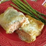Salmon in phyllo cut in half on a plate with asparagus cut