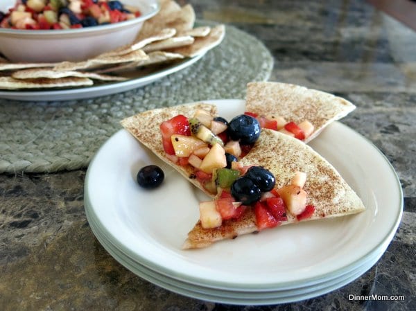 Fruit Salsa on top of cinnamon chips on a stack of plates.