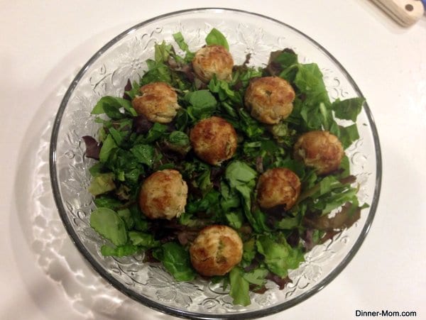 Crab Cake Bites made in a cake pop maker on top of lettuce on a glass plate