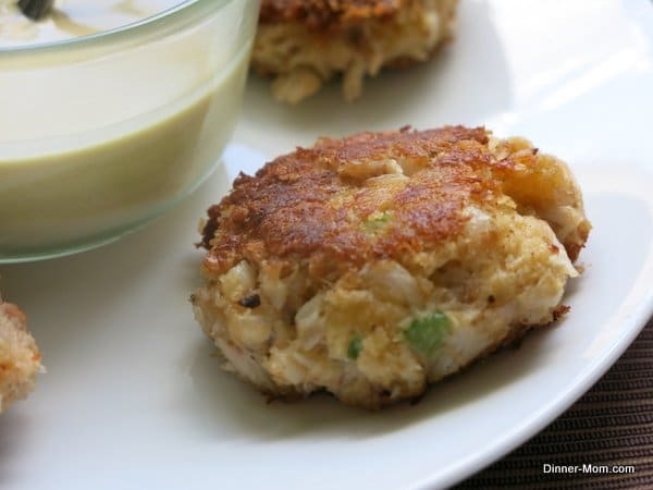 Maryland Style Crab Cakes on plate with sauce in the middle of plate.