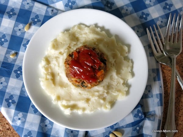 Spinach and Pine Nut Meatloaf Muffin on top of plate of mashed potatoes