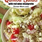 Greek quinoa salad with red wine vinegar dressing in a bowl.