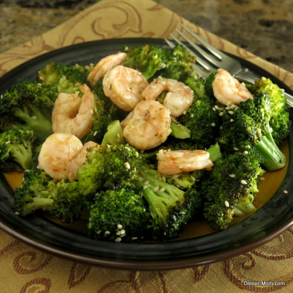 Sesame Roasted Broccoli with shrimp on top on a plate