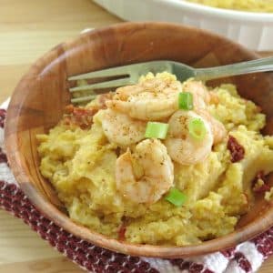 Skinn shrimp and grits in a bowl with a fork