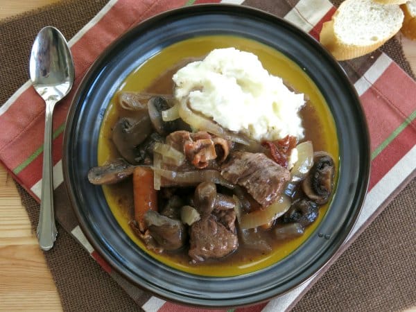 Slow Cooker Beef Bourguignon on a plate with mashed potatoes.