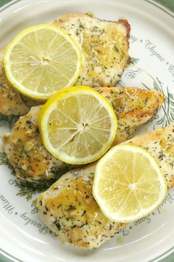 3 Pan Fried Chicken Cutlets in lemon sauce on plate with lemon slices on top