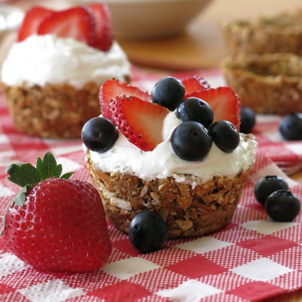 No-Bake Mini Cheesecakes in Pretzel Crust Cups topped with blueberries and strawberries