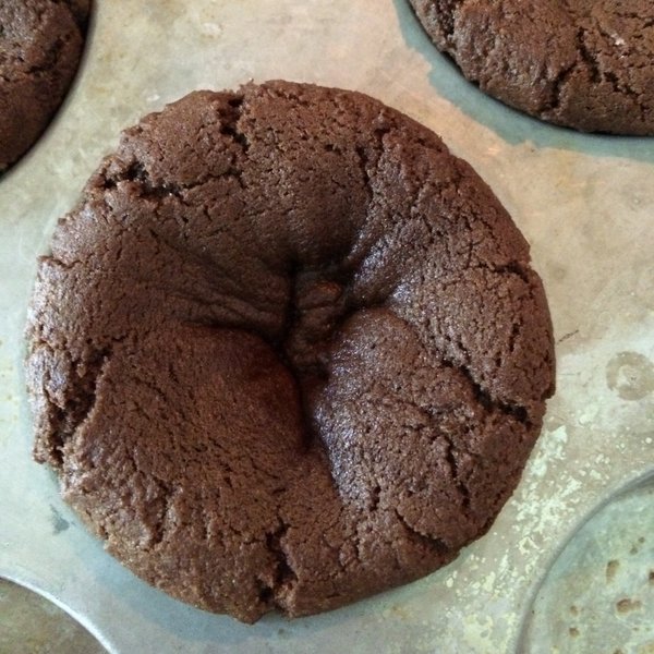 Double Chocolate Chip Cookie dough in muffin tin with slight indentation from being partially cooked.