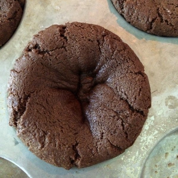 Double Chocolate Chip Cookie dough in muffin tin with slight indentation from being partially cooked