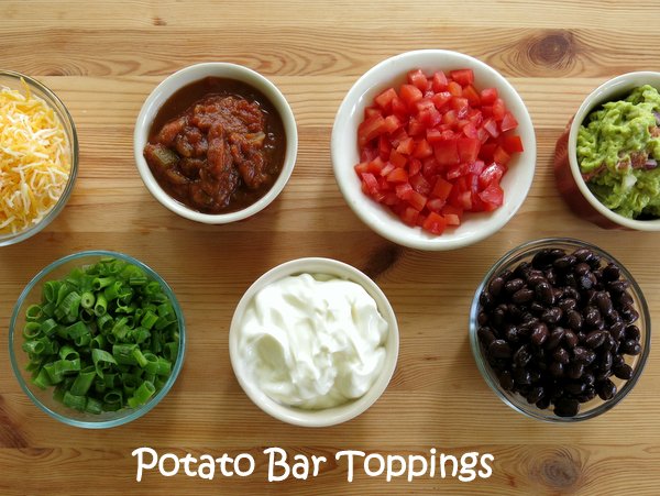 Toppings for baked potatoes in bowls on bar