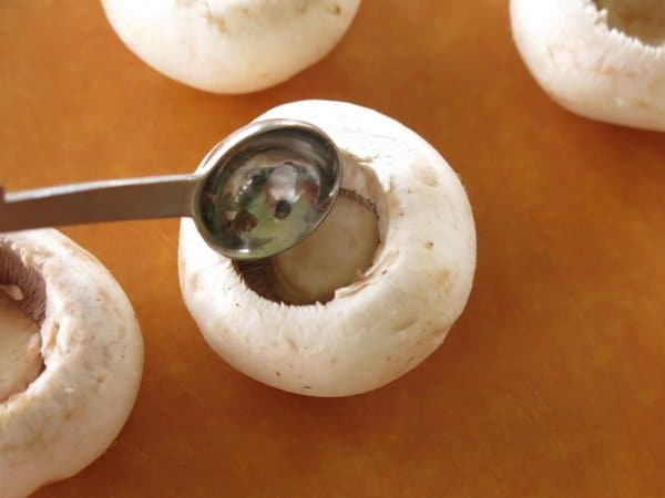 A small measuring spoon scooping out the inside of the mushroom.