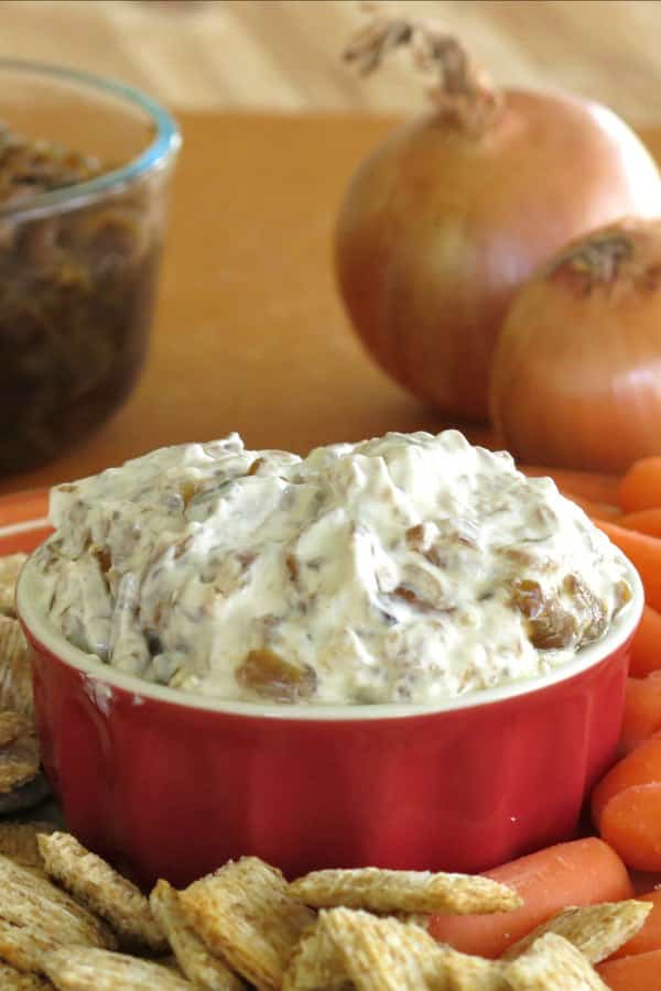 Bowl of skinny onion dip with Greek yogurt with onions in the background
