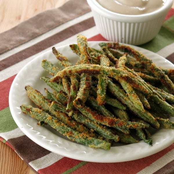 Frites de haricots verts cuites au four sur une assiette et trempette de yogourt balsamique