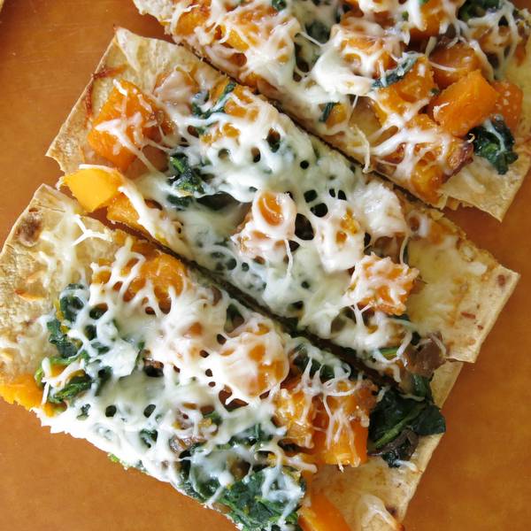 Roasted Butternut Squash Pizza with Caramelized Onion in slices on a board