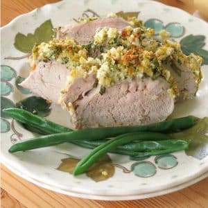 Sliced Herb Crusted Pork Tenderloin on plate with green beans