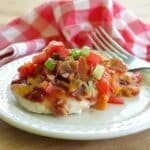 Copycat Chili's Monterey Chicken on a plate with a red checkered napkin and fork behind it.