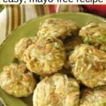 Avocado crab cakes on a green plate with avocado cream sauce behind it and text overlay that says: Avocado Crab Cakes - easy, mayo-free recipe.