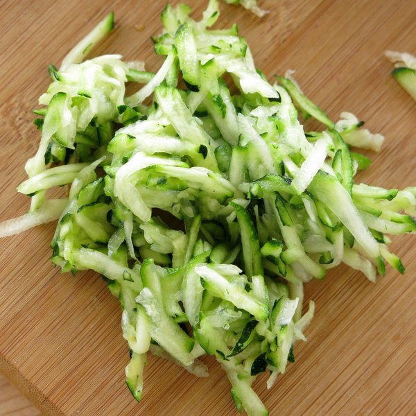 A pile of zucchini shreds on a cutting board