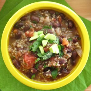 Easy Black Bean Quinoa Soup Recipe in a bowl topped with avocado and cilantro