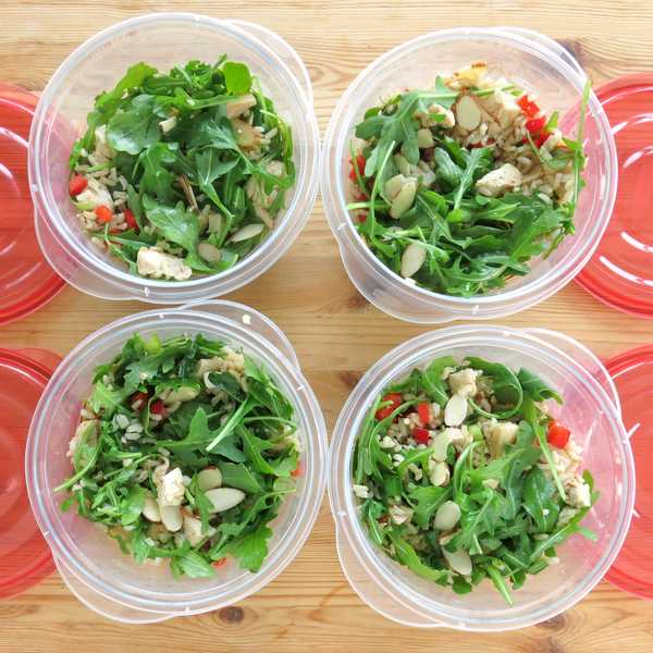 Cold Chicken Arugula Rice Salad in 4 containers next to lids for lunches.