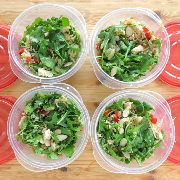 Cold Chicken Arugula Rice Salad in 4 containers next to lids for lunches.