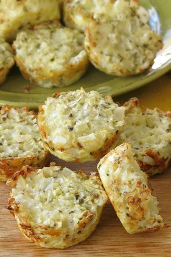 Cauliflower muffins stacked near a plate