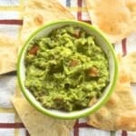 Bowl of one avocado guacamole surrounded by tortilla chips.