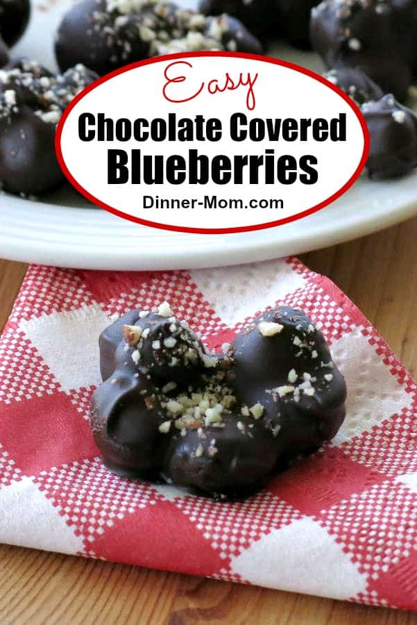 Dark Chocolate Covered Blueberries topped with almonds are so much better than storebought version. It's easy to make these homemade clusters! #chocolatecoveredblueberrries #candyrecipe