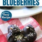 Dark chocolate covered blueberries clustered together on a red checkered napkin.