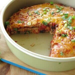 Layered Burrito Pie Casserole in pan with a slice removed.