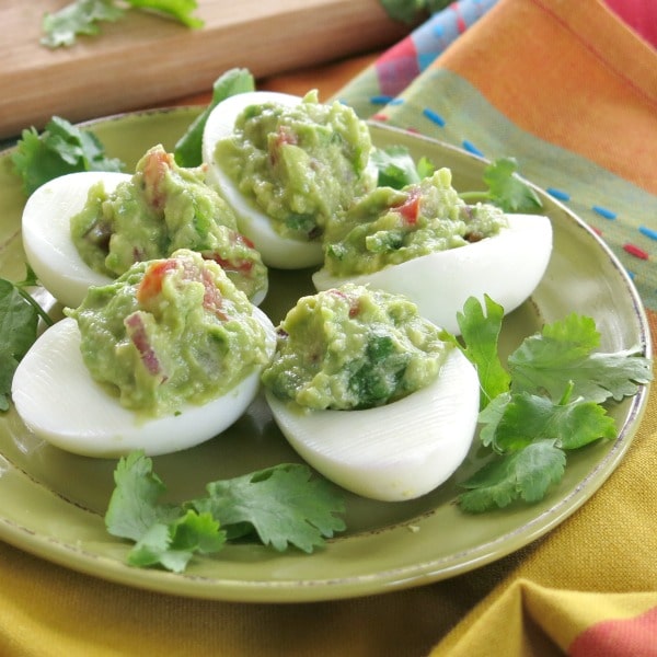 5 egg haves stuffed with guacamole on a plate