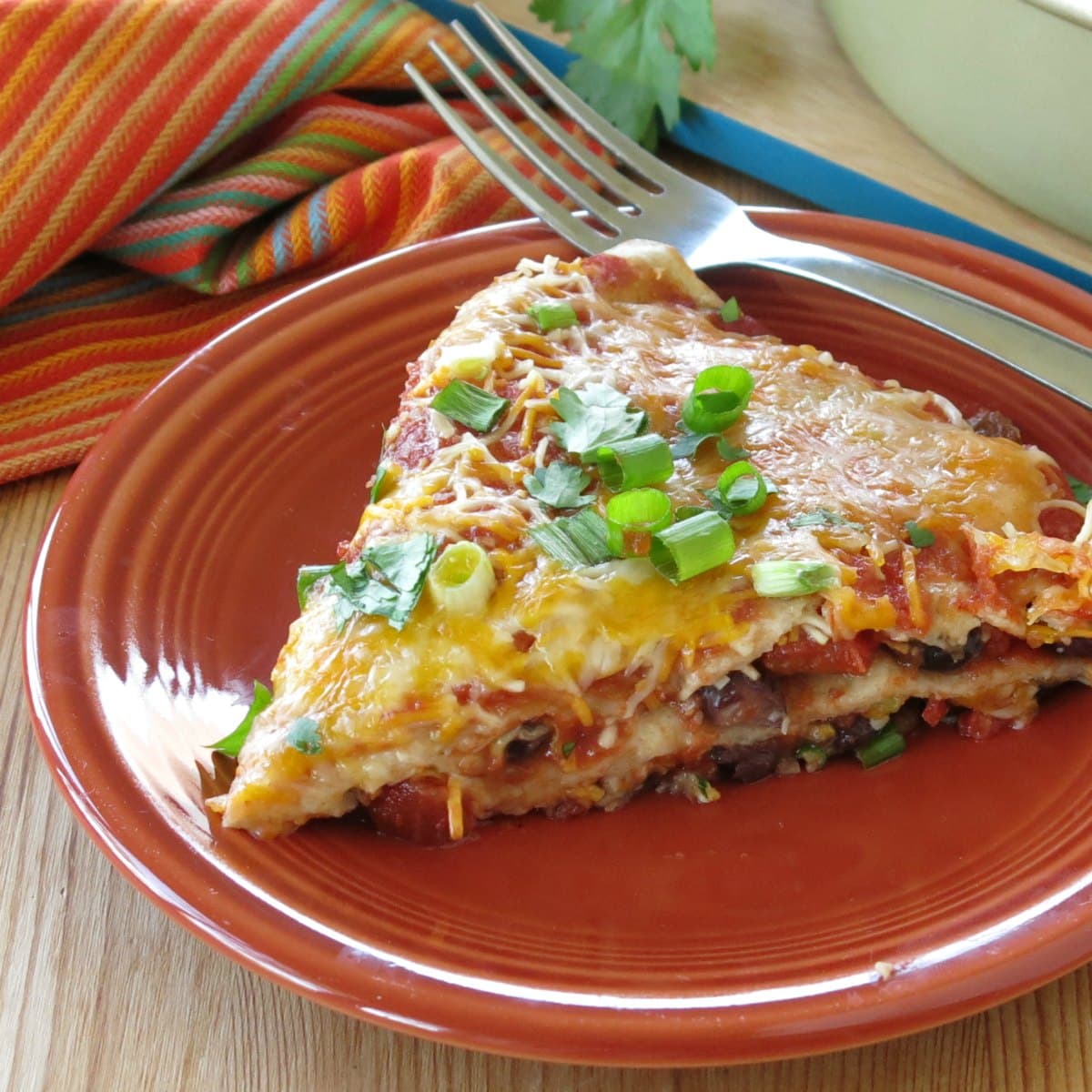 Slice of layered burrito pie casserole on plate with a fork