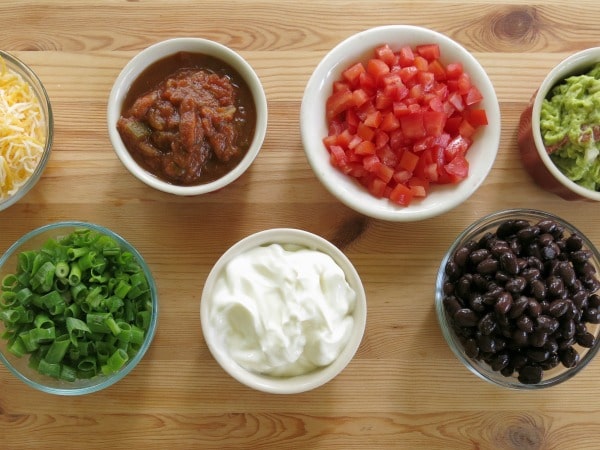 A variety of Mexican toppings in small bowls