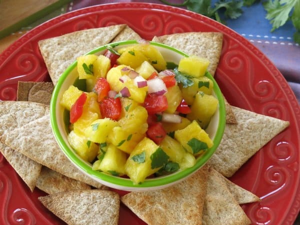 Simple Pineapple Salsa in bowl surrounded by homemade tortilla chips