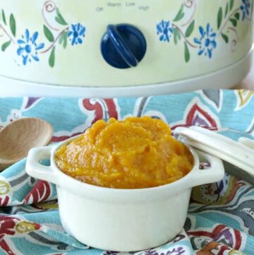 Crock-pot butternut squash in a bowl in front of a slow cooker