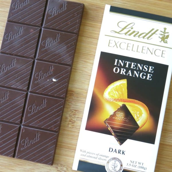 Unwrapped Lindt Intense Orange Dark Chocolate bar with packaging next to it