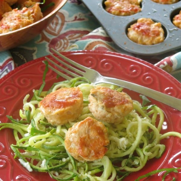 chicken meatballs over zoodles on a plate with fork