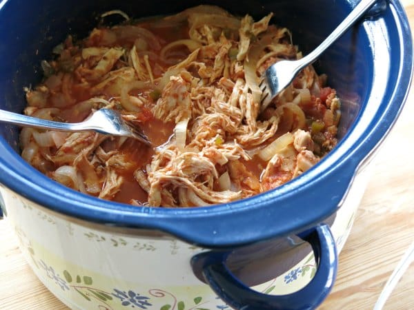 2 forks shredding 3 ingredient salsa chicken in a crock-pot