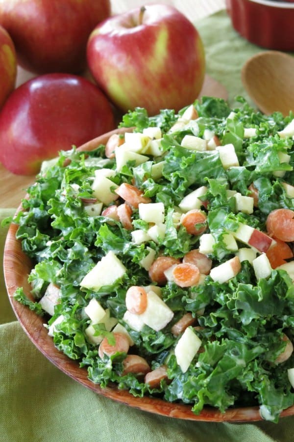 Easy Kale Apple Slaw mounded in bowl with apples next to it