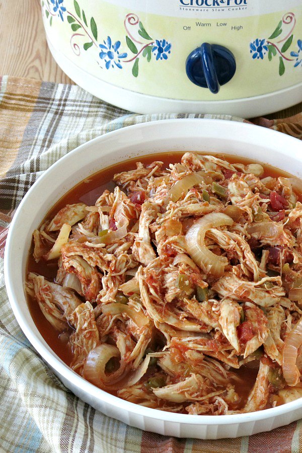 Healthy Salsa Chicken in serving dish with crock-pot in the background