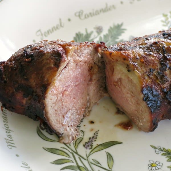 Pork Tenderloin cooked in red wine marinade cut in half on a platter