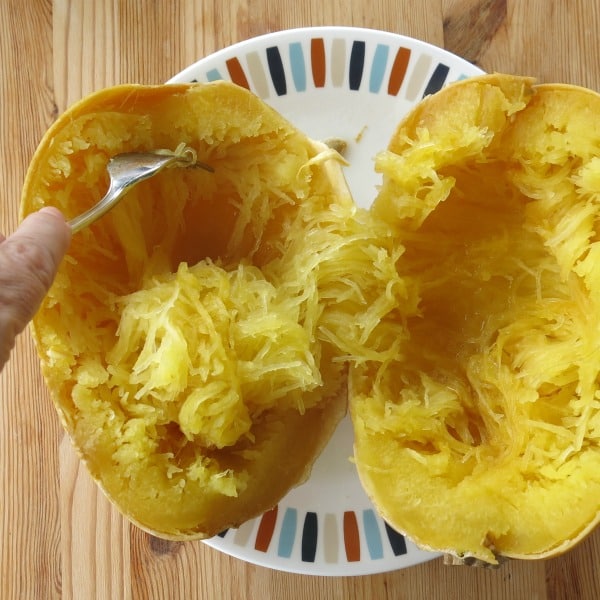 Fork scraping strands from a Spaghetti Squash Cut in Half