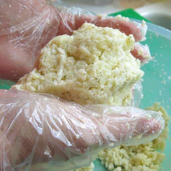 Hands holding a ball of cauliflower pizza dough.