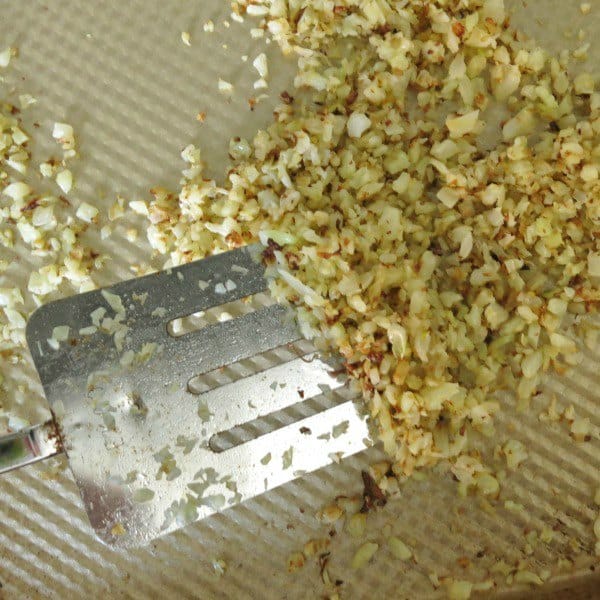 Crispy Cauliflower Rice on Pan being turned over by a spatula