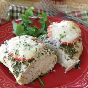 Healthy Pesto Chicken on plate cut into two pieces with fork in background.