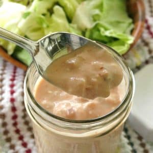 Spoon lifting Healthy Taco Salad Dressing out of mason jar