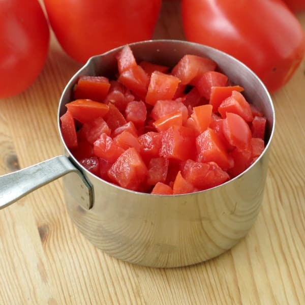 Diced plum tomatoes in a measuring cup.